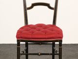 a black chair with a red cushion on top of it
