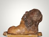 a statue of a lion on a wooden stand