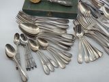 a lot of silverware on a table with a book in the background