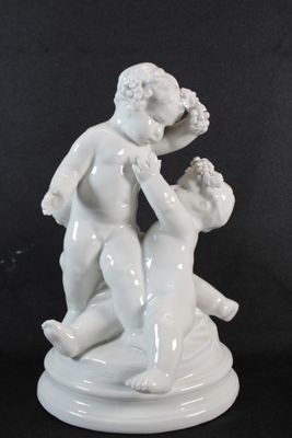 une statue représentant un garçon et une fille sur un socle