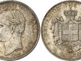 une pièce d'argent sur laquelle figurent la tête d'un homme et des armoiries