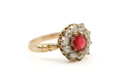 gros plan d'une bague en or avec une pierre rouge