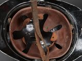 an old helmet with a leather strap hanging from it ' s side