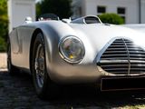 a silver sports car parked in front of a white building