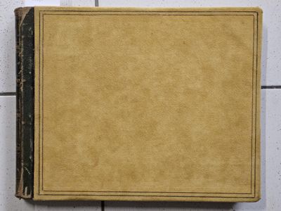 an old book sitting on top of a tiled floor next to a wall