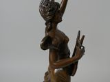 bronze statue of a woman holding a bird on a white background