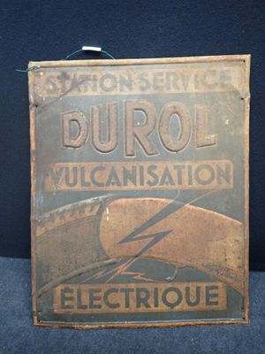 une vieille enseigne métallique annonçant la vulcanisation Durol sur fond bleu