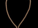 un collier en or orné de pompons sur fond noir