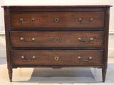 a wooden chest of drawers with brass handles on it
