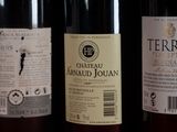several bottles of wine are lined up on a shelf
