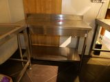 a stainless steel table in the middle of a kitchen