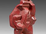 a red sculpture of a man with a hat on his head
