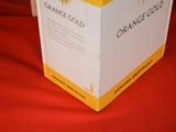 a box of orange wine sitting on a red cloth