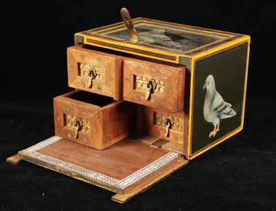 a small wooden box with drawers and a bird on it