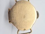 a close up of a gold watch on a white surface