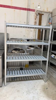 stainless steel shelvings in a commercial kitchen with a sink and stove
