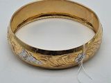 an image of a gold bangle with a tag on it