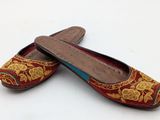 pair of red and gold slippers on a white surface