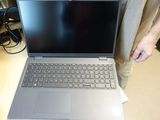 someone is standing next to a laptop computer on a table