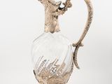 a silver and glass vase with a bird on top of it