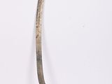 a small metal object with a long handle on a white surface