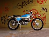 a motorcycle parked in front of a wall with graffiti on it