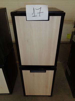 two black and white refrigerators with a sign on top of them