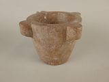a stone vase that is sitting on a white surface
