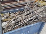 un conteneur bleu rempli de barres d'acier et d'autres outils
