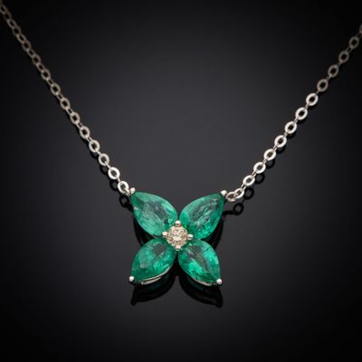 un gros plan d'un collier orné d'une fleur verte