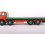 a toy truck with a flat bed on a white surface