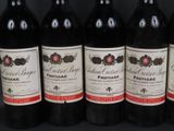 six bottles of wine are lined up on a black surface
