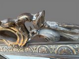 a bronze statue of a man and a woman on a mirror