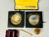 a small box with two gold coins and a wooden box with a spoon