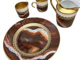 a plate, cups, and a pitcher on a table