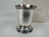 a silver cup sitting on a table next to a box