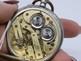 a close up of a pocket watch being held in someone ' s hand
