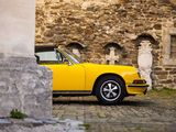 a yellow car that is parked in front of a stone building