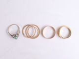 five different rings arranged in a row on a white surface