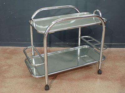 un chariot de service en métal et en verre posé à même le sol