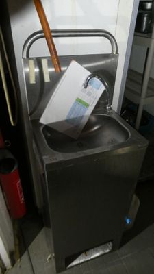 a metal sink with a box on top of it