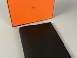 un portefeuille orange et noir posé à côté d'une boîte orange