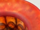 a close up of a red vase with a hole in it