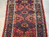 an antique persian rug with red and blue colors