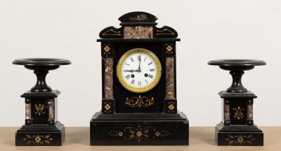 trois horloges noires et dorées posées sur une table