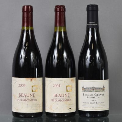 three bottles of red wine are lined up on a glass table