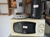 two microwaves on top of each other in a room