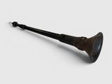 une vieille pipe repose sur une surface blanche, avec un manche noir