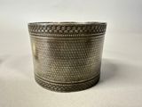 a close up of a silver cup on a white surface