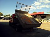 a dump truck with a metal basket on the back of it